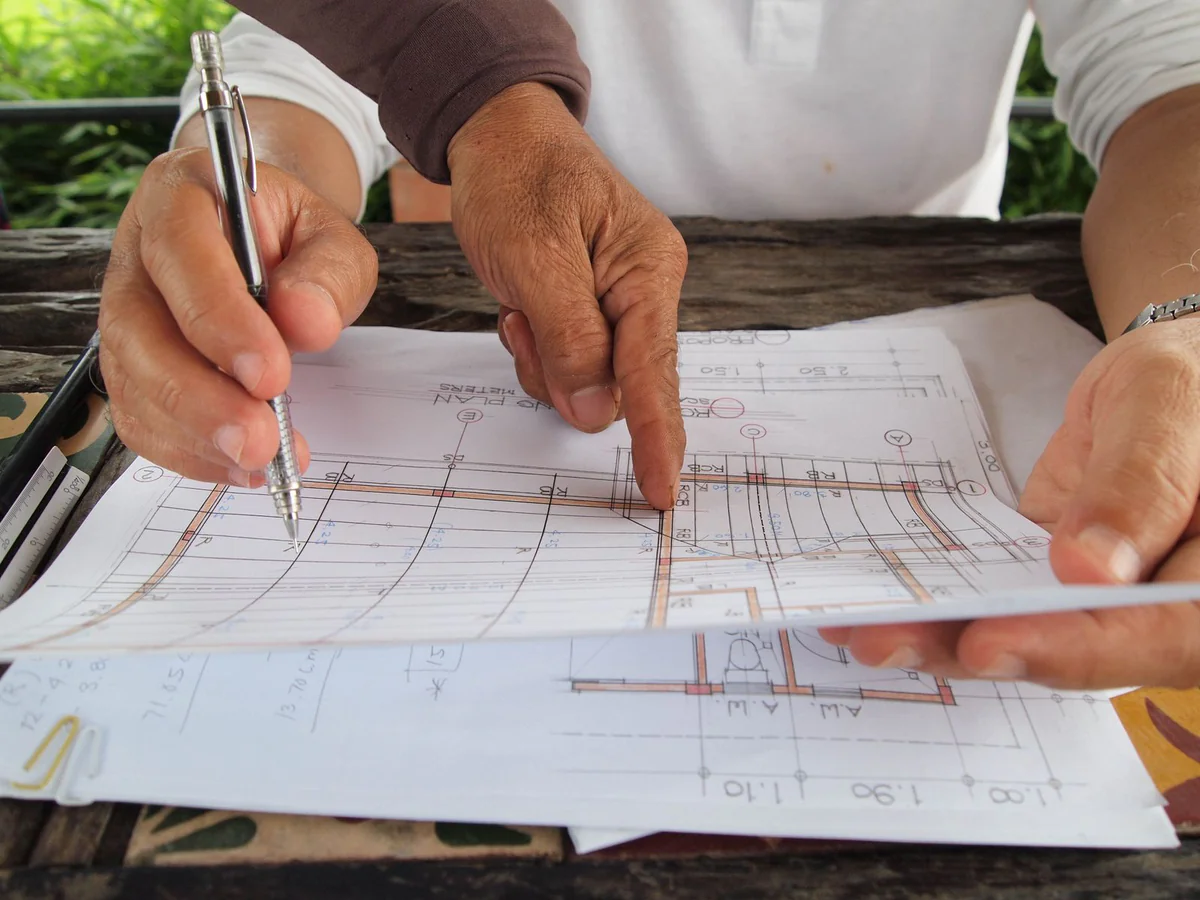 Hands reviewing a building plan