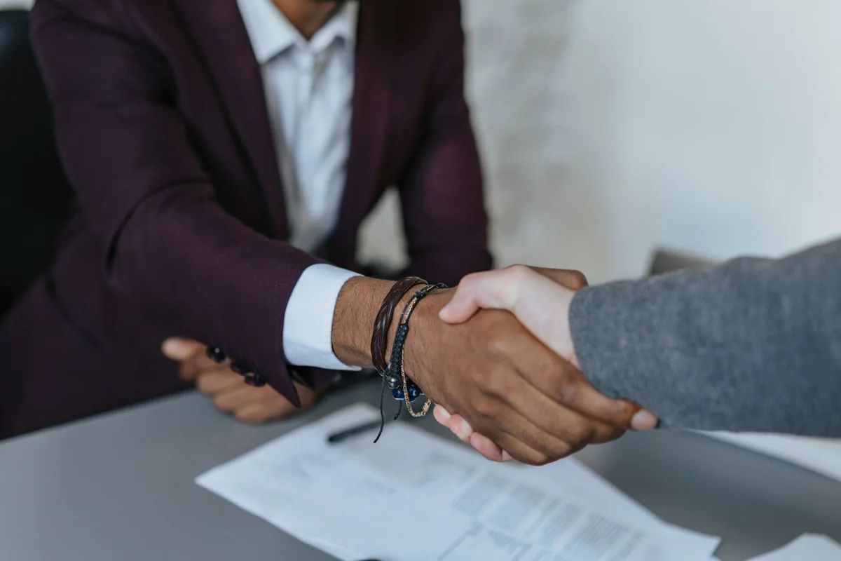A handshake across a desk