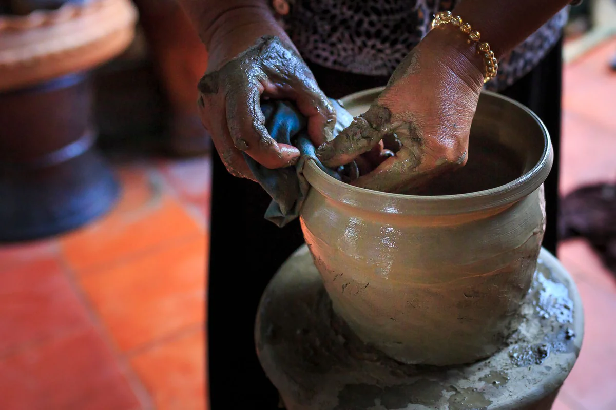 Hands shaping clay on a wheel