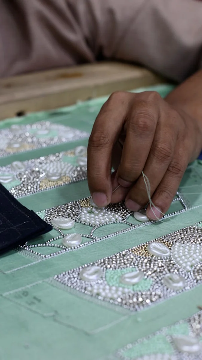 A karigar hand-finishing a garment at our atelier