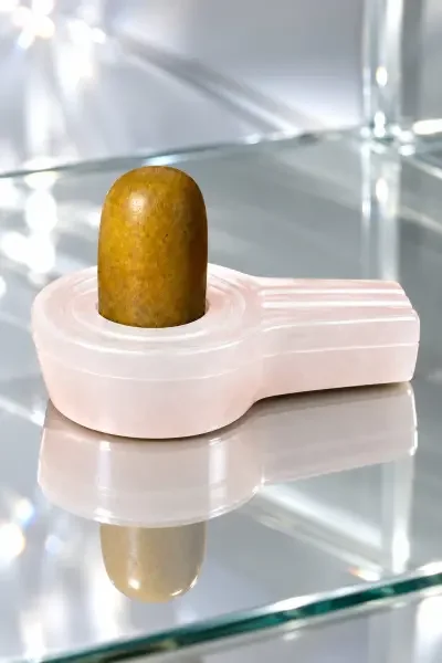 Golden-brown NavaPashanam Shivling with white Flat Sphatik Quartz Vedi, showcased in a luxurious glass setting.