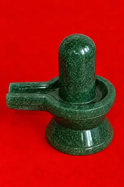 Green Aventurine Shivling shown against a vibrant red background, highlighting its polished gemstone surface and deep green tone.