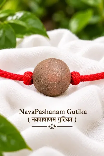 NavaPashanam Gutika with red thread, elegantly displayed on white fabric with natural green accents.
