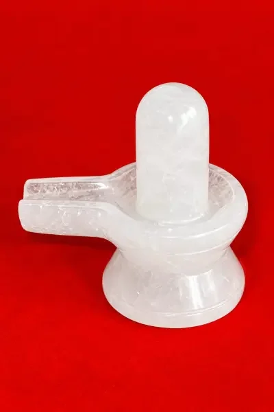 Original Sphatik Shivling displayed against a vibrant red background, highlighting its smooth white crystal form.