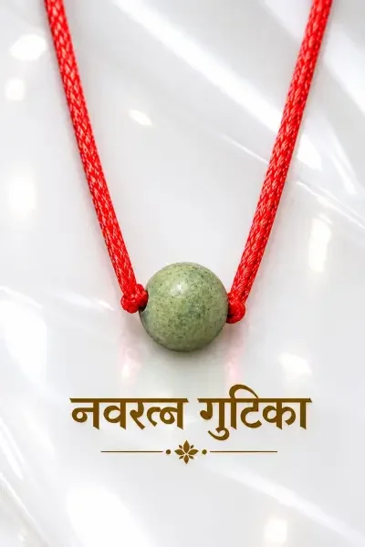 Navaratna Gutika 10 Gram featuring a green spherical bead tied with a red thread, presented on a bright glossy white surface with a clean luxury aesthetic.