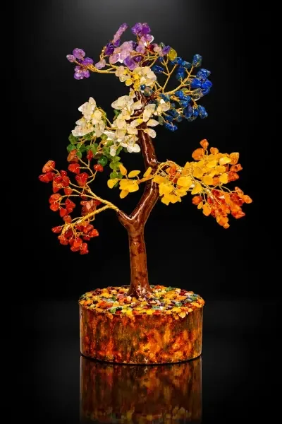 Premium 7 Chakra Gemstone Tree featuring colorful natural gemstone chips arranged across gold-tone branches, displayed against a dramatic black background.