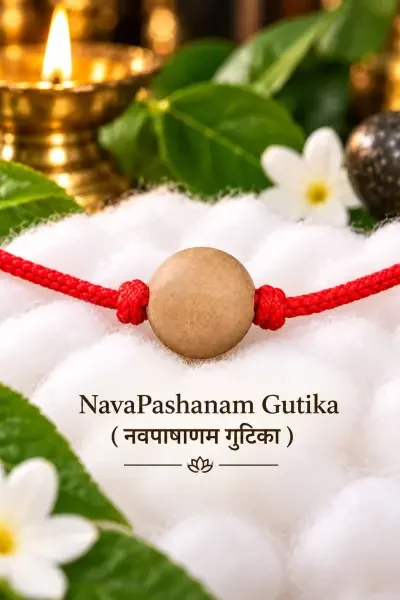 Traditional NavaPashanam Gutika with a rounded beige bead and red thread, styled on a soft white backdrop with पूजा elements.
