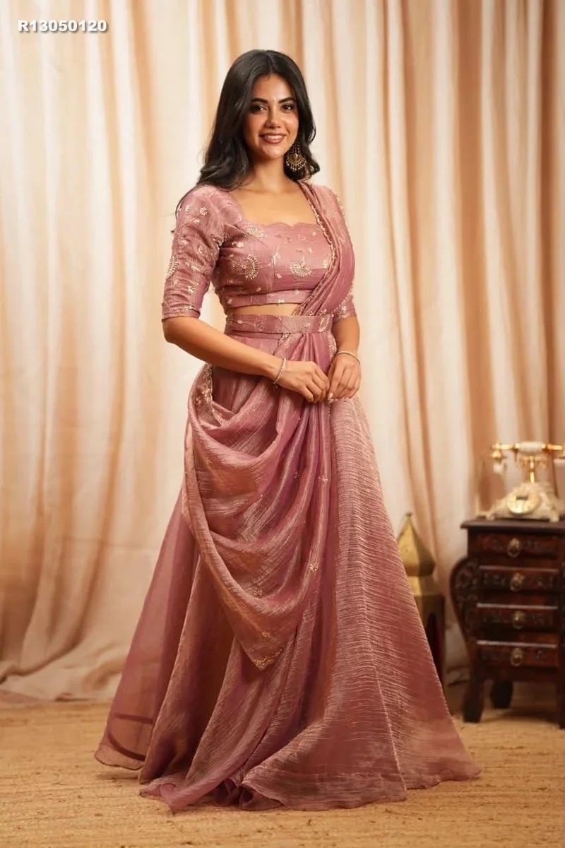 Rk ethinics.. Draped in dusty rose, this lehenga radiates refined glamour. Shimmering beadwork adds graceful sparkle to every movement. Flowing volume creates a regal