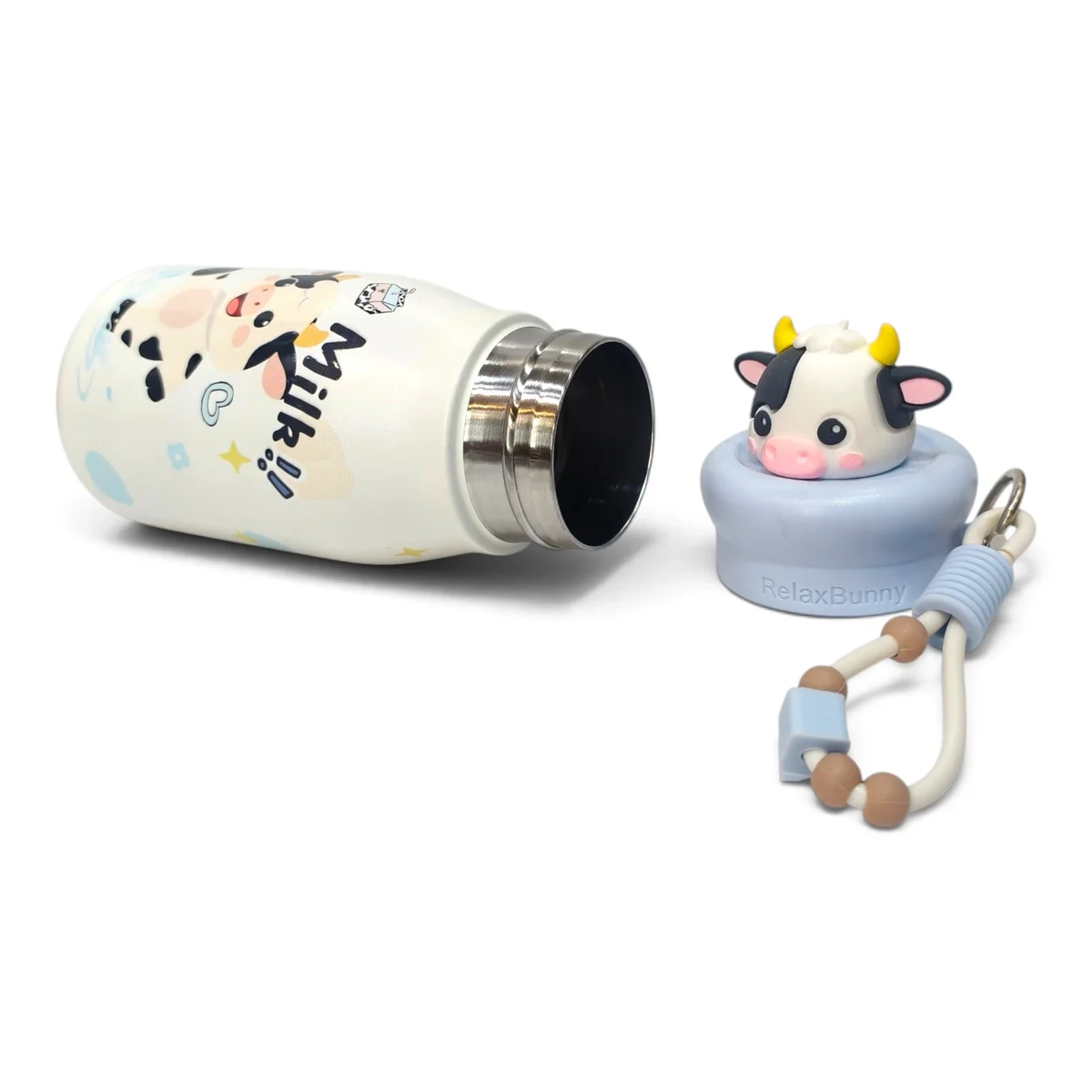 The bottle is shown lying horizontally with the cow character cap removed and placed beside it. The image clearly displays the bottle opening, removable cap ass